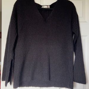 Black sweater. Wide sleeves with slits on bottom